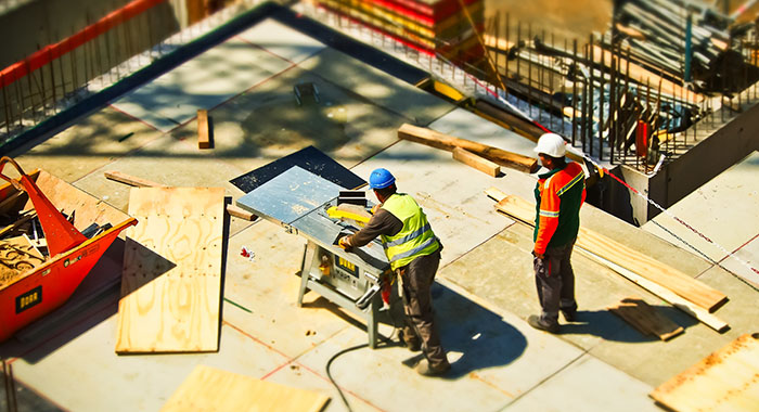 Dwóch pracowników pracujących na placu budowy