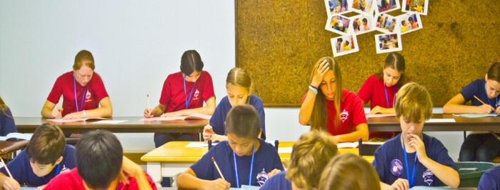 Uczniowie siedzący przed biurkami w szkole
